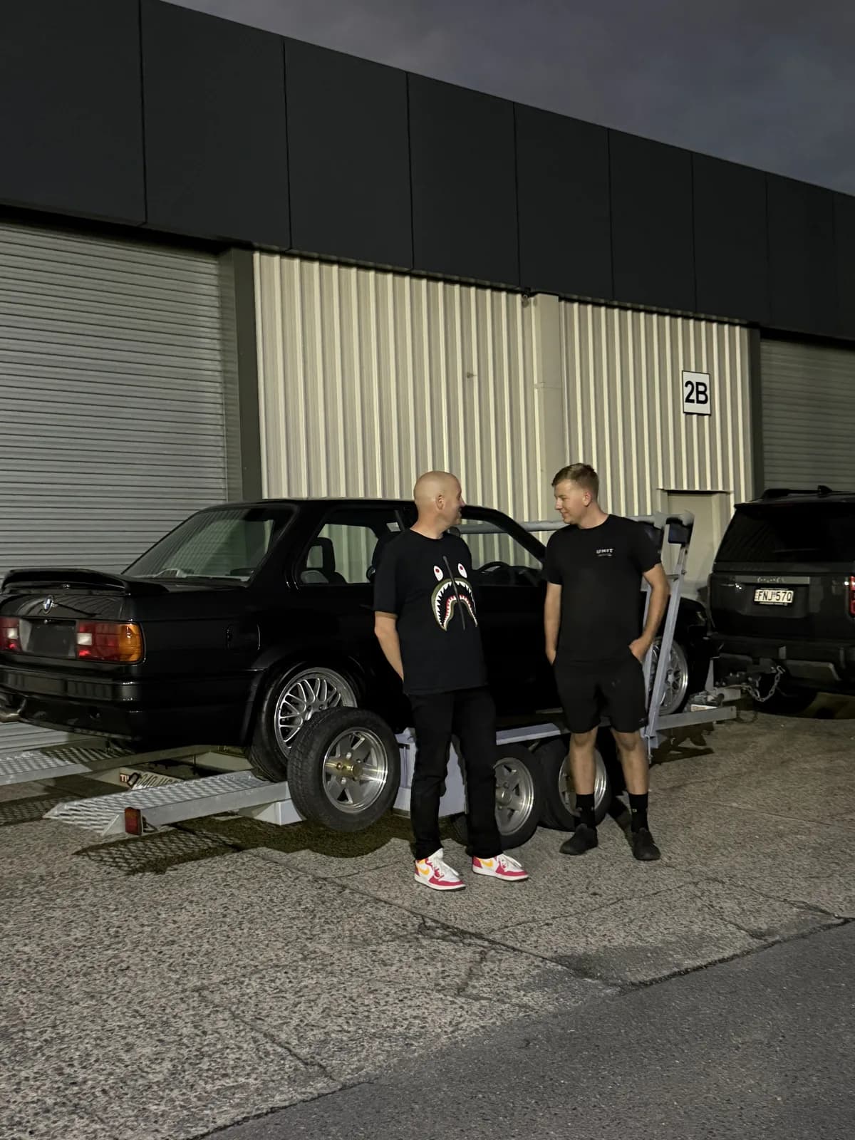 The crew with a BMW E30 M3 at a Brisbane workshop