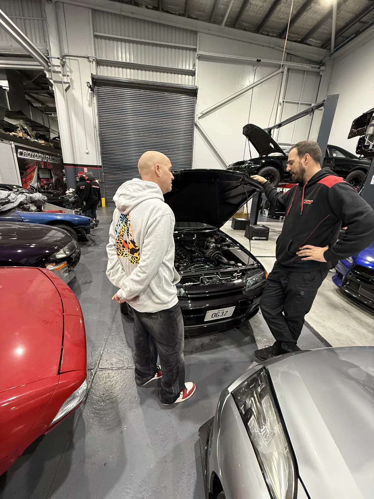 The crew inspecting a Nissan Skyline R32 GT-R engine bay