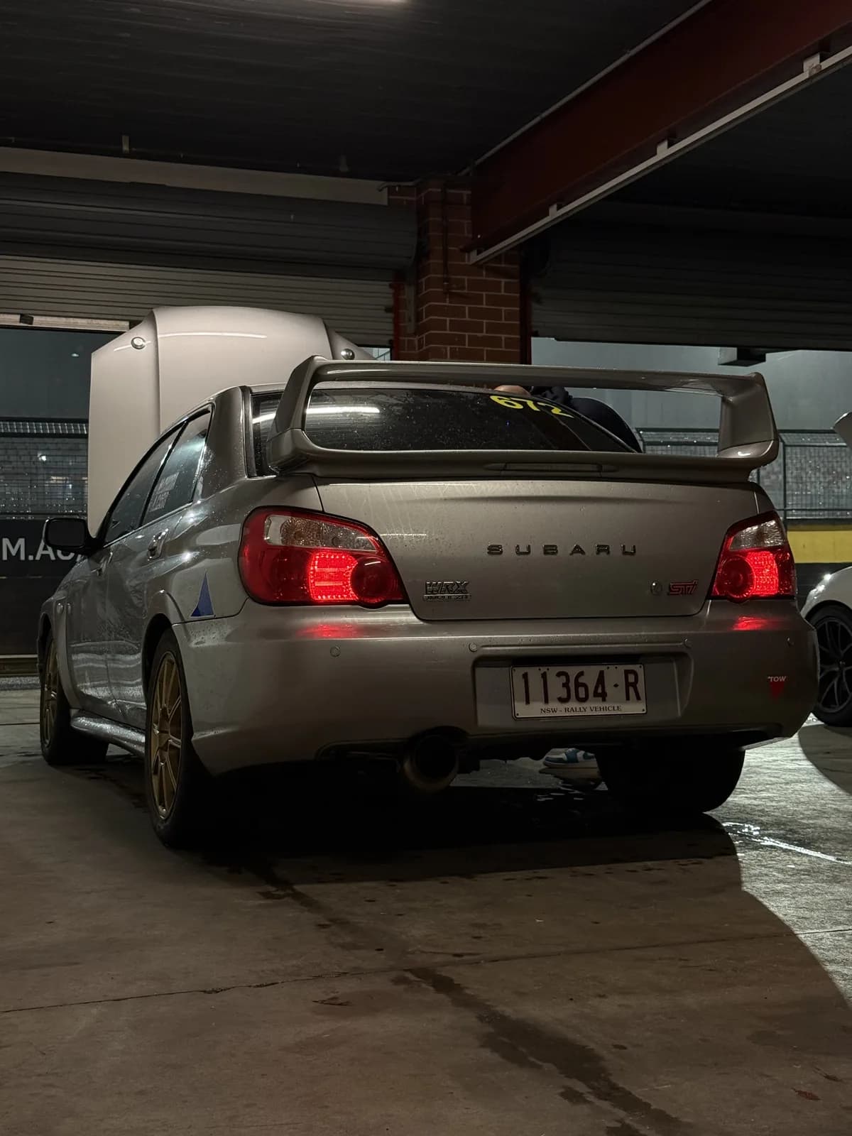 Betsy, the Shakewell Racing Subaru WRX STI, under the workshop lights at night
