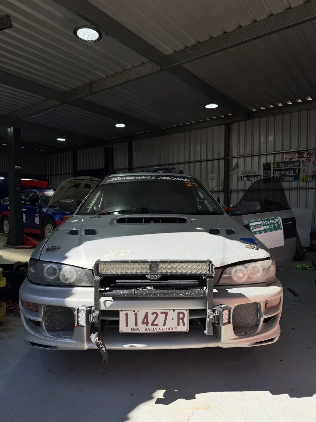 The Shakewell Racing Impreza wagon in the shed before prep, still dusty and wearing its Ada River Rally door plates