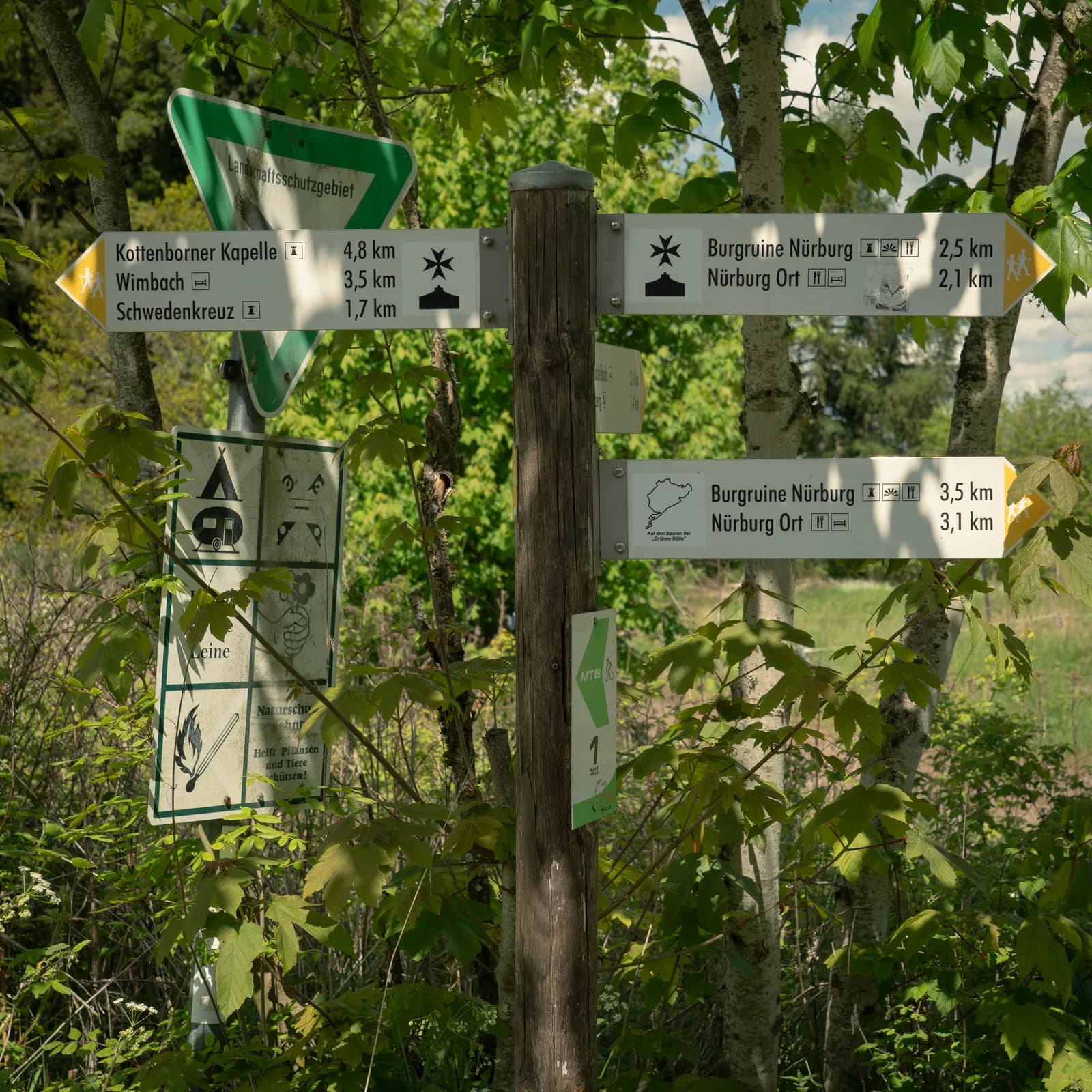 A walking-trail signpost pointing to the Nürburg castle ruins