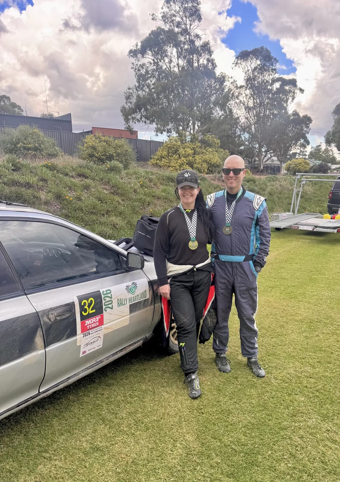 Michael Chora and Rachael Ferrante with their medals beside the rally car at the Rally of the Heartland