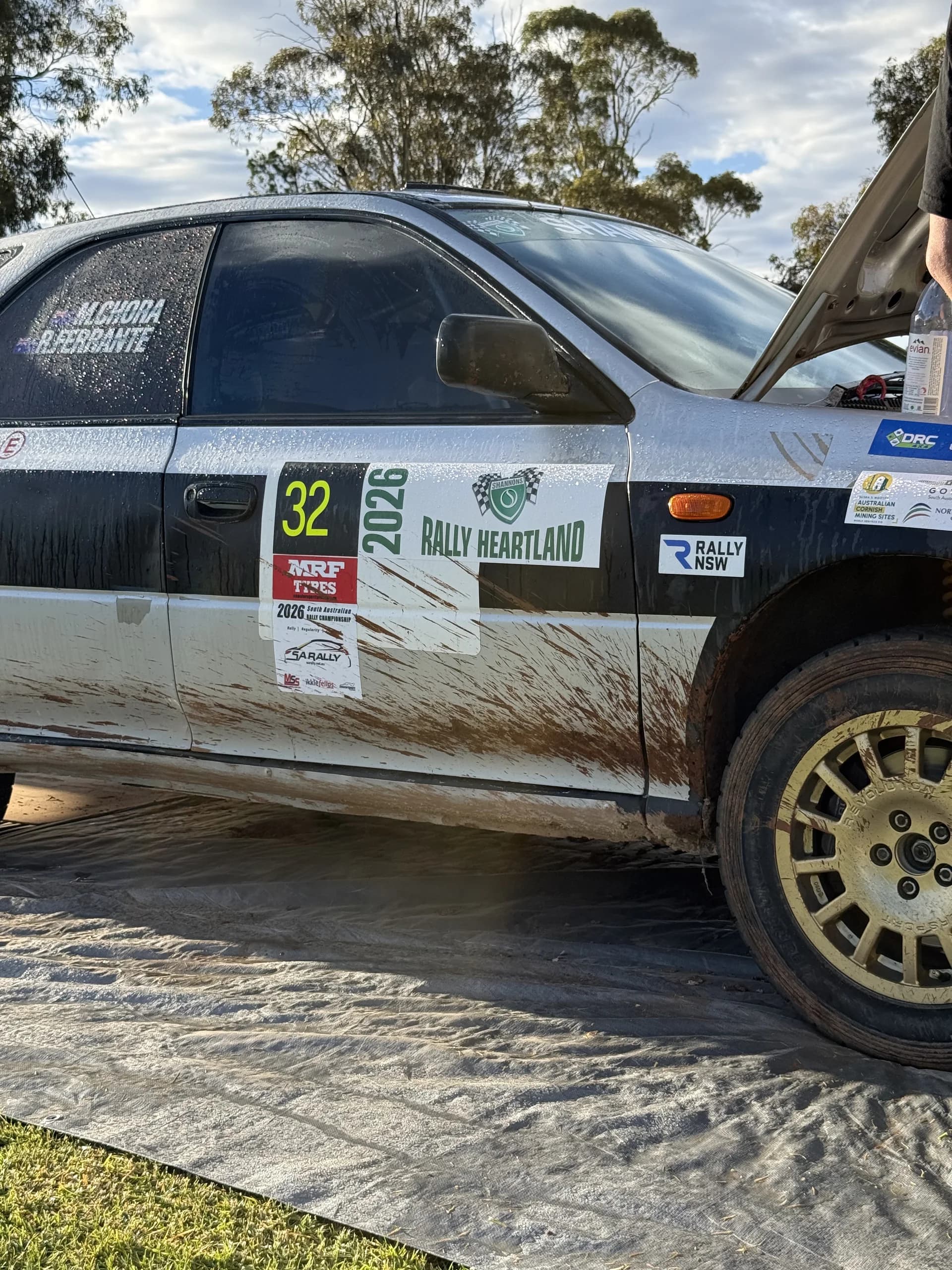 The mud-streaked side of car 32 after a wet Rally of the Heartland stage