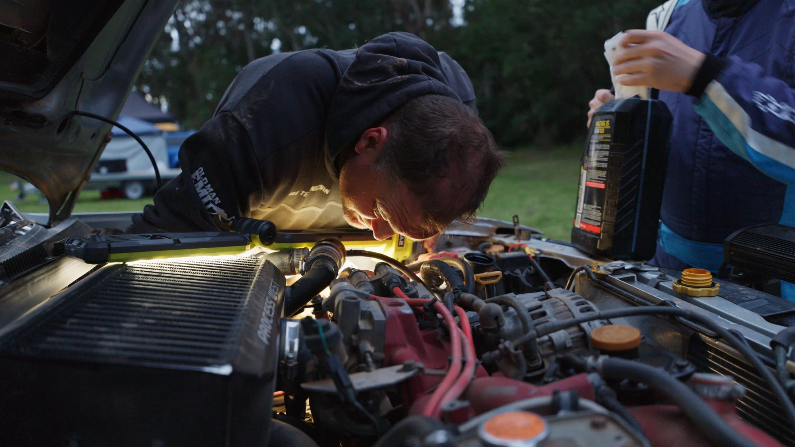 Head torch on in the engine bay during a night service at the Narooma Forest Rally