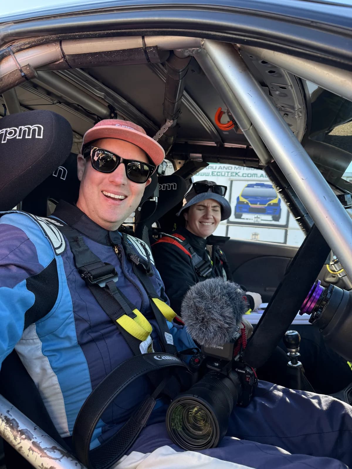 Michael Chora and Rachael Ferrante smiling in the rally car at the Lazer Rally of the Bay