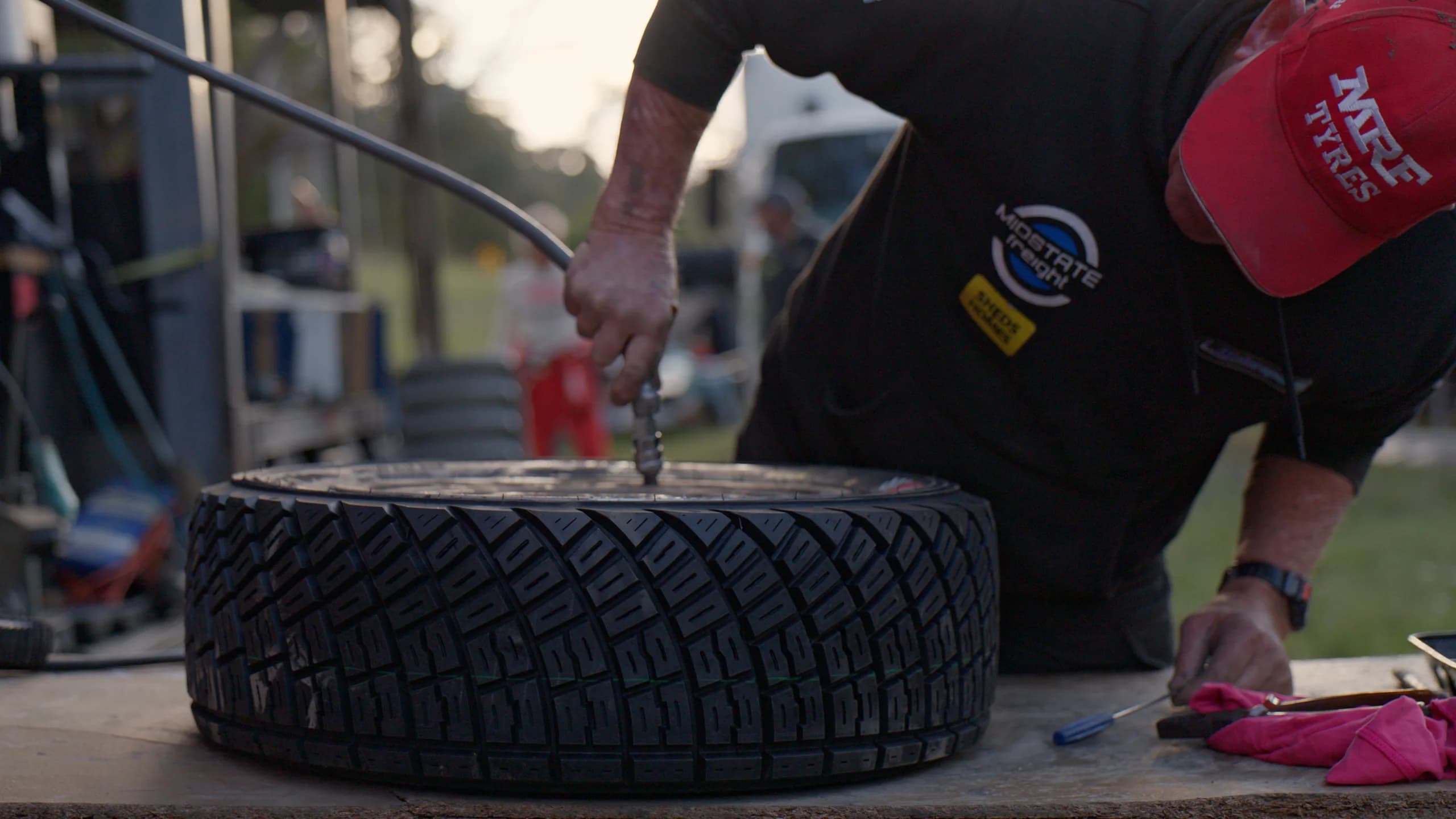 A spare tyre and tools laid out at service during the Ada River Rally
